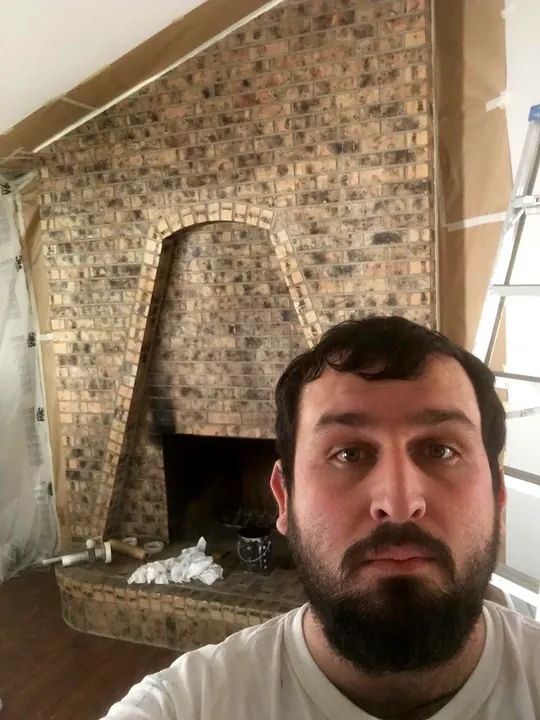 Abel in front of a freshly painted brick fireplace